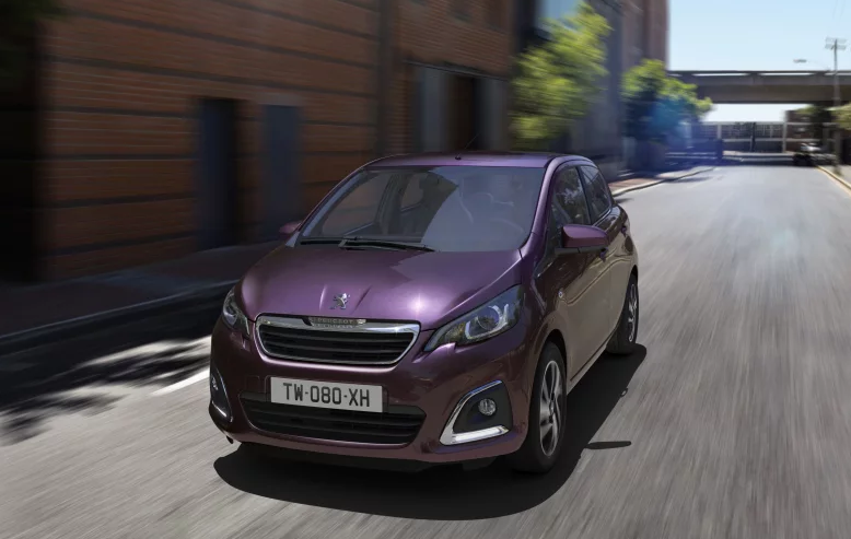 Purple Peugeot 108 whizzing down a road towards you
